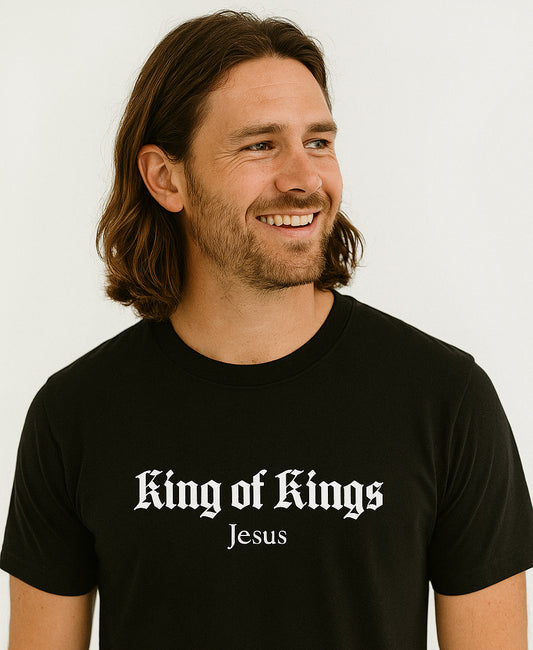 Man wearing a black t-shirt with 'King of Kings Jesus' text on a white background